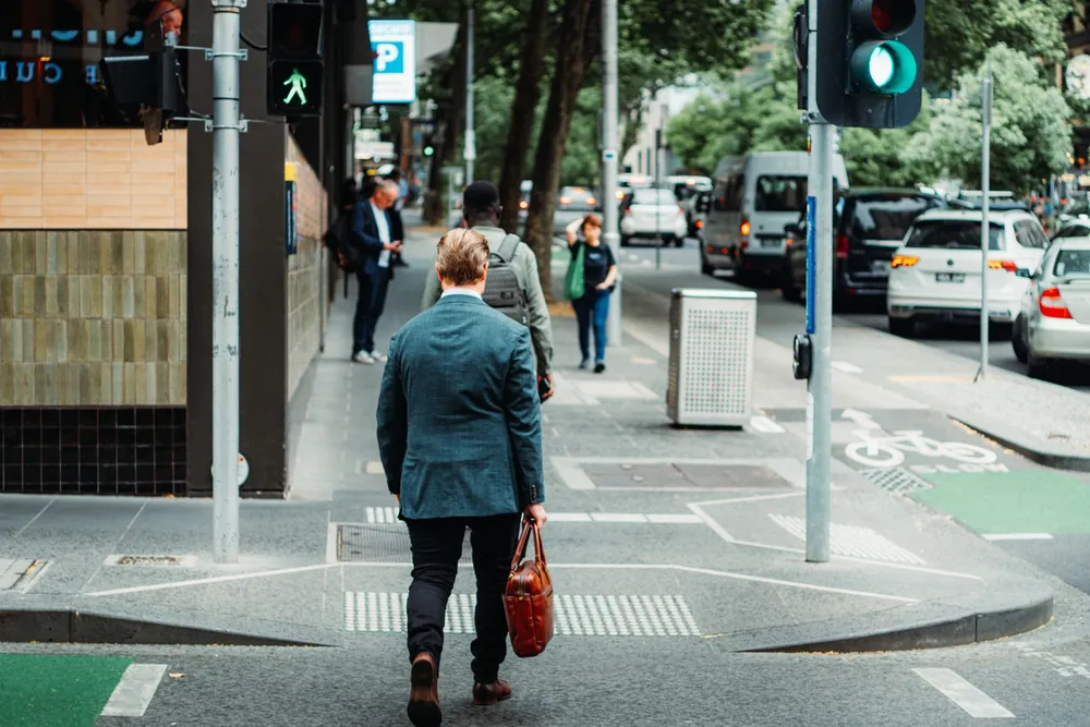 Homme d'affaires traversant une rue animée d'une ville australienne