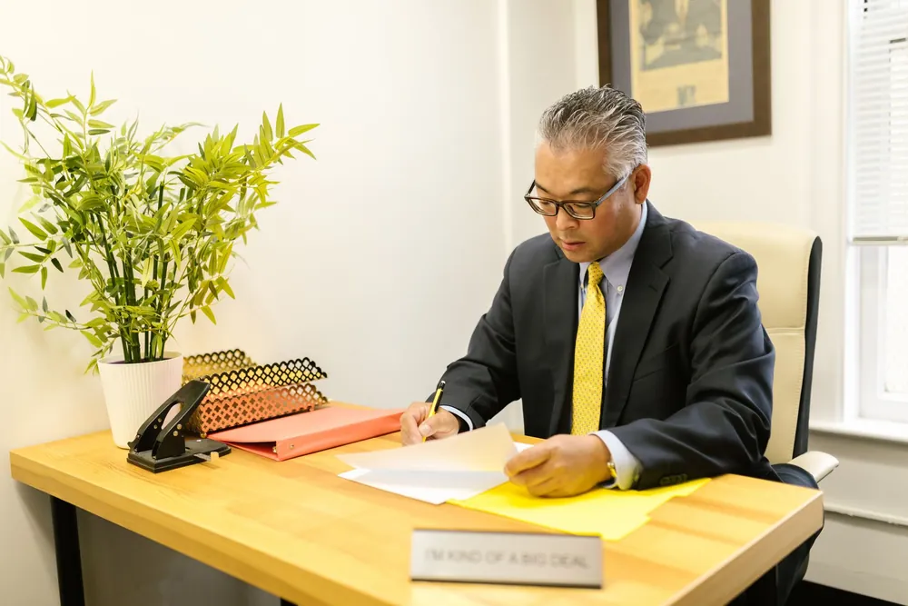 Homme en tenue professionnelle consultant des documents dans un bureau
