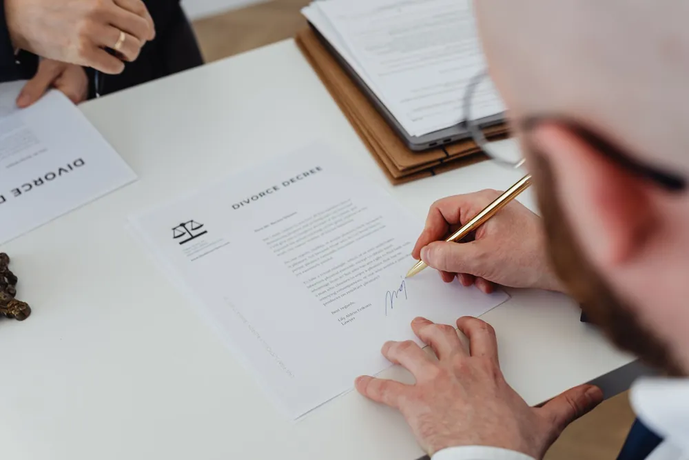 Signature d'un document officiel posé sur un bureau
