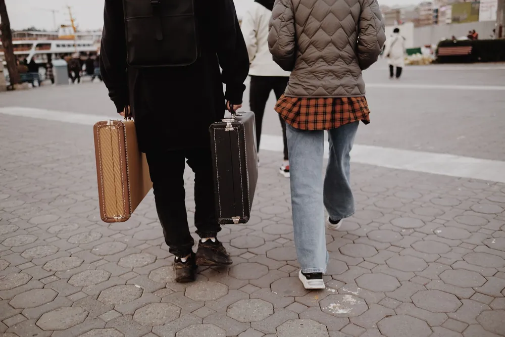 Deux voyageurs traversant une ville avec leurs valises
