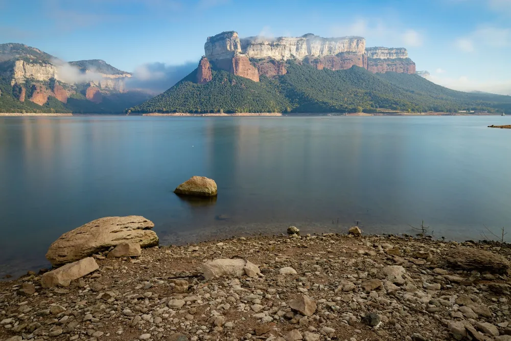 Le réservoir de Sau entouré de montagnes sous un ciel dégagé en Espagne