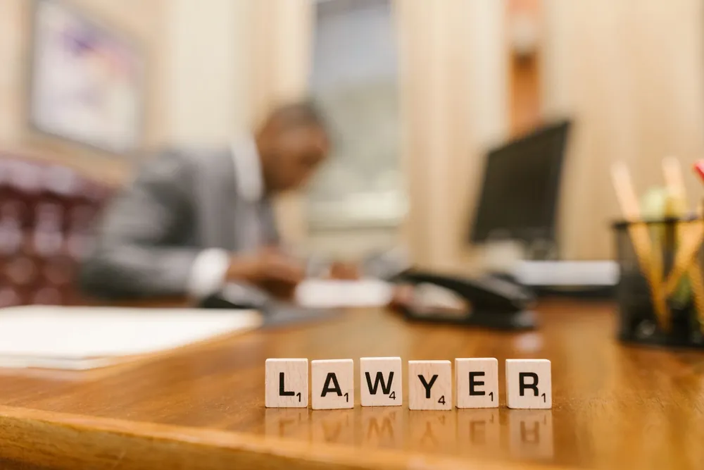 Des lettres en bois formant le mot lawyer sur un bureau d'avocat