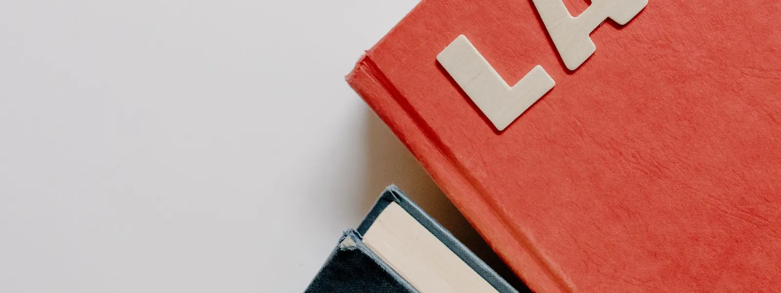 Des manuels de droit posés sur un fond blanc symbolisent les études juridiques