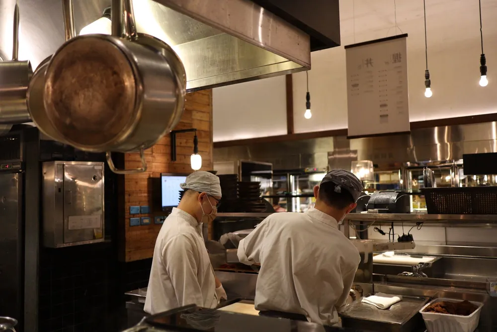 Deux chefs cuisinent ensemble dans une cuisine professionnelle de restaurant