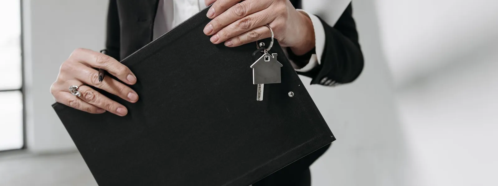 Agent immobilier tenant un trousseau de clés et un dossier
