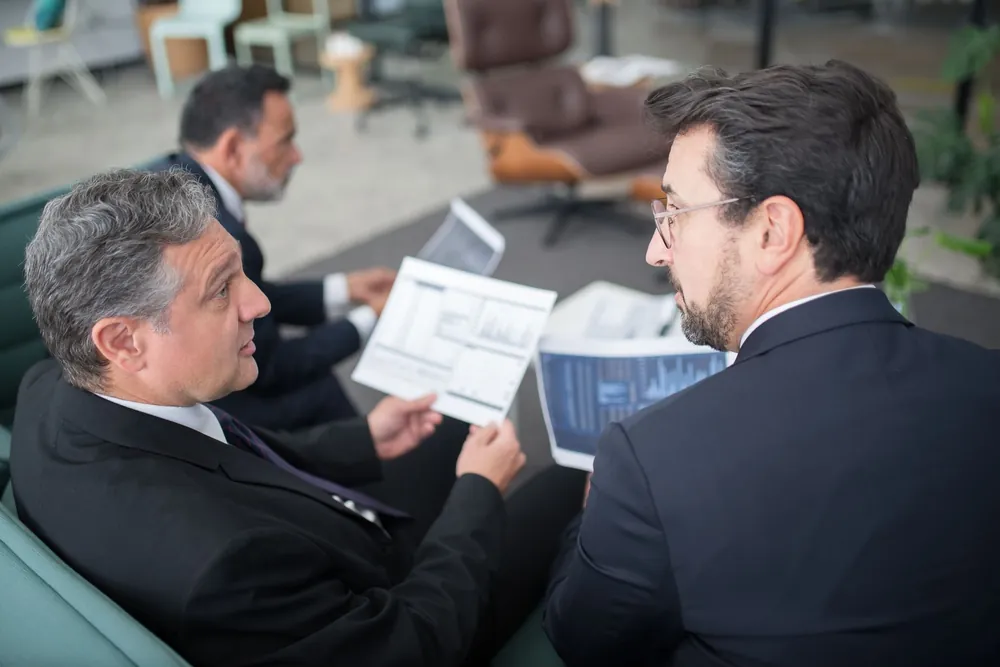 Trois collègues discutant de documents financiers au bureau