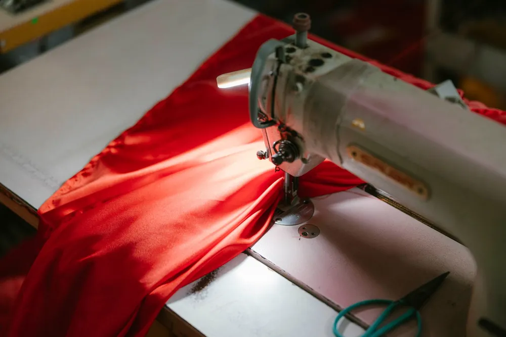 Machine à coudre industrielle piquant un tissu rouge vif