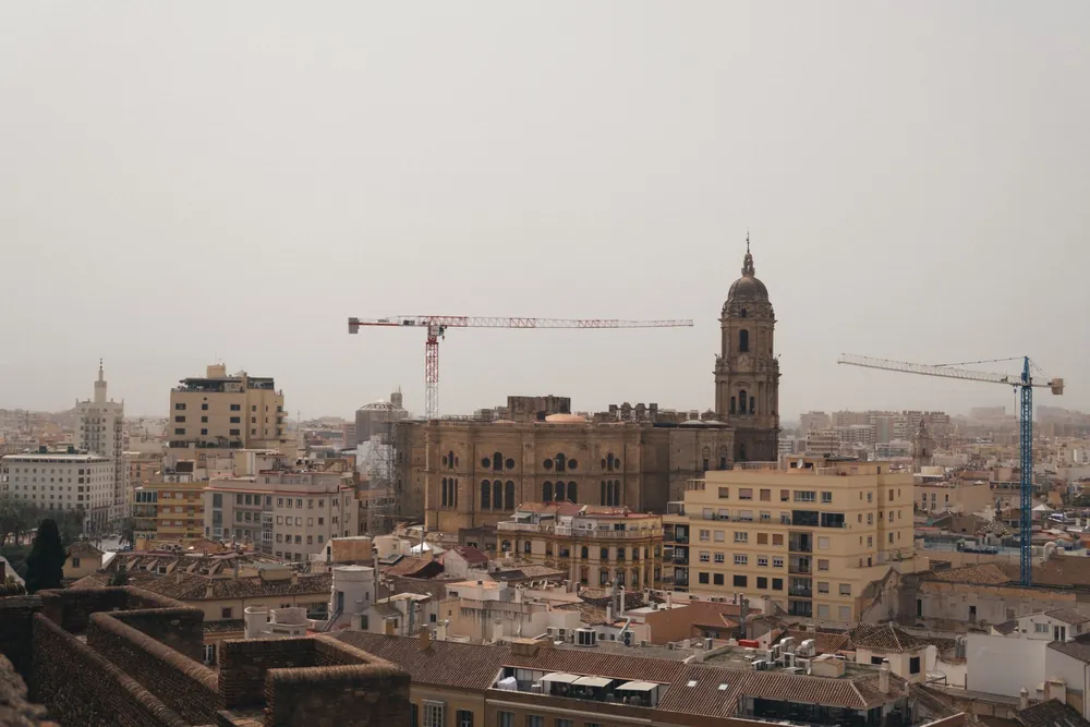La cathédrale de Malaga se dresse parmi les grues et immeubles urbains