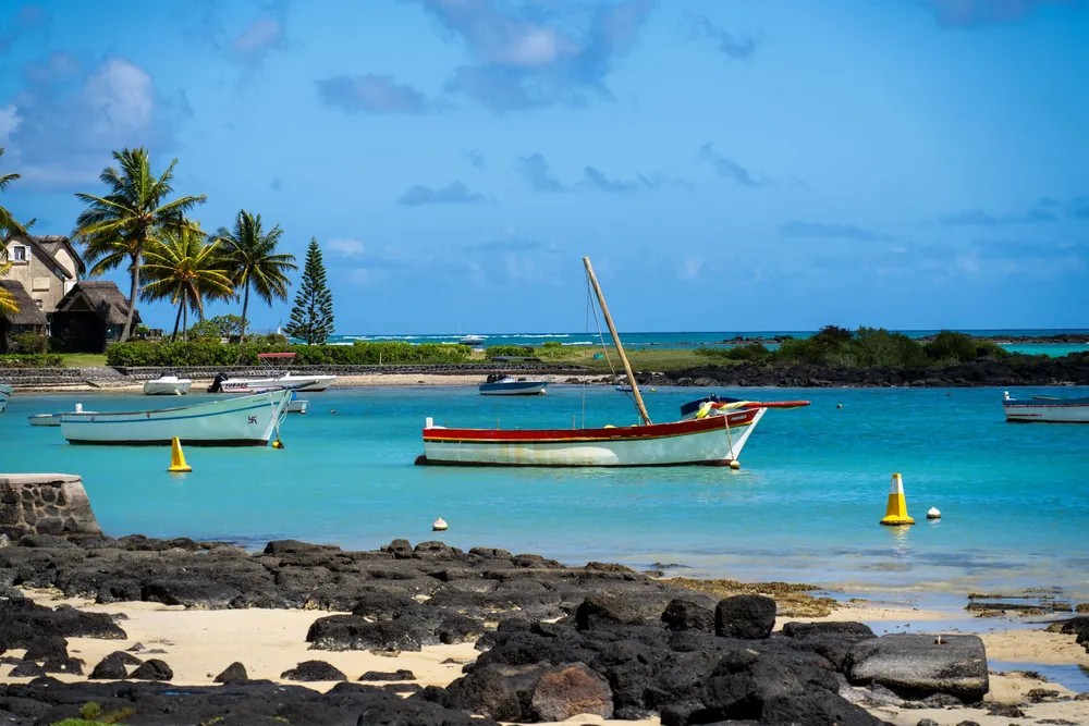 Plage tranquille avec bateaux et palmiers en bord de mer mauricien