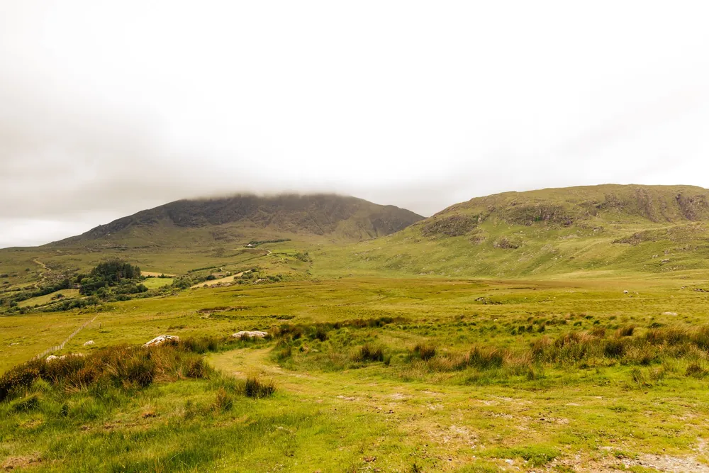 Les montagnes verdoyantes du Kerry sous un ciel nuageux en Irlande