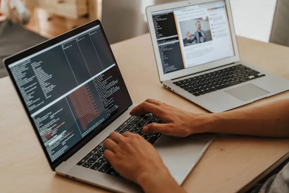 Développeur tapant du code sur un ordinateur portable dans le cadre d'une candidature