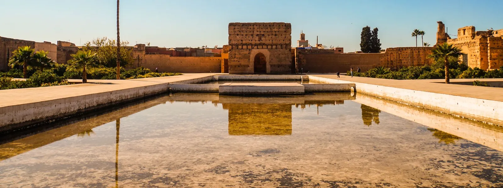 Palais El Badi à Marrakech avec bassin réfléchissant sous ciel bleu