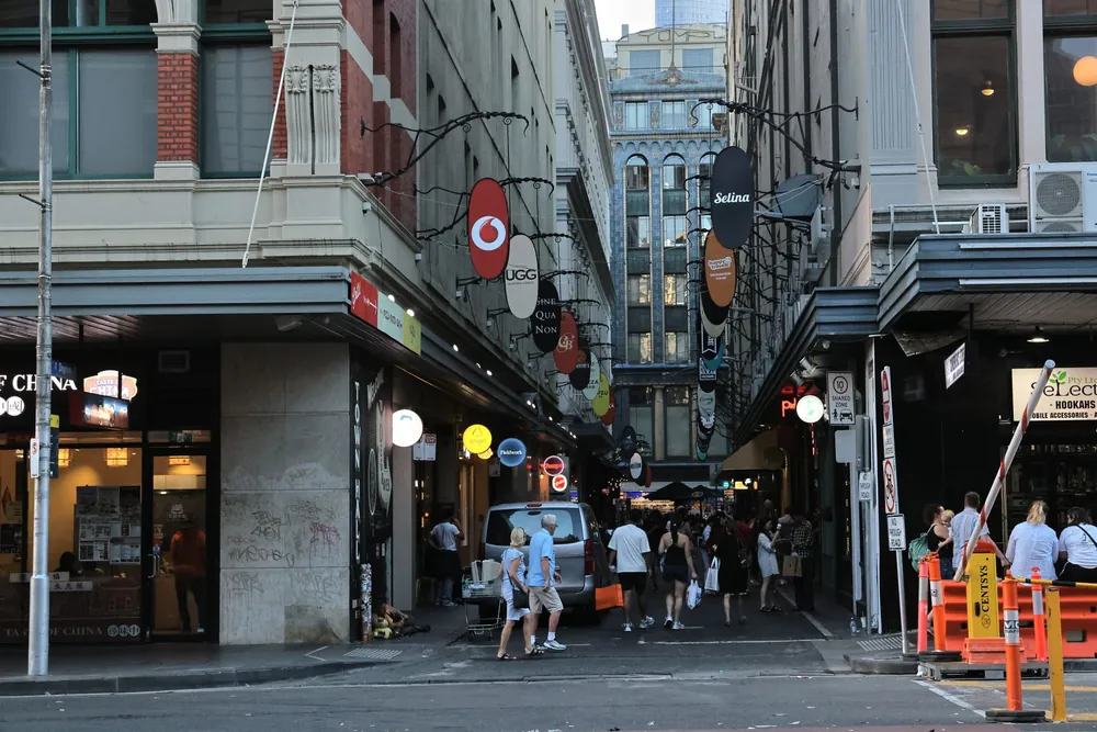 Ruelle animée de Melbourne bordée de commerces et d'enseignes lumineuses