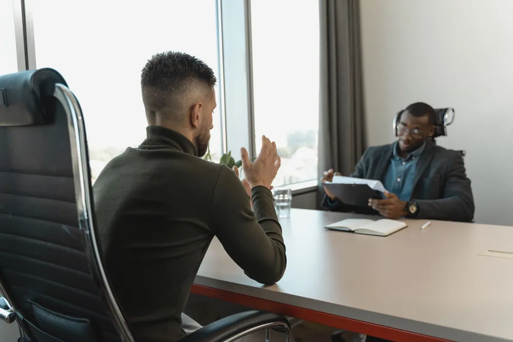 Deux hommes en entretien professionnel dans un bureau moderne et lumineux