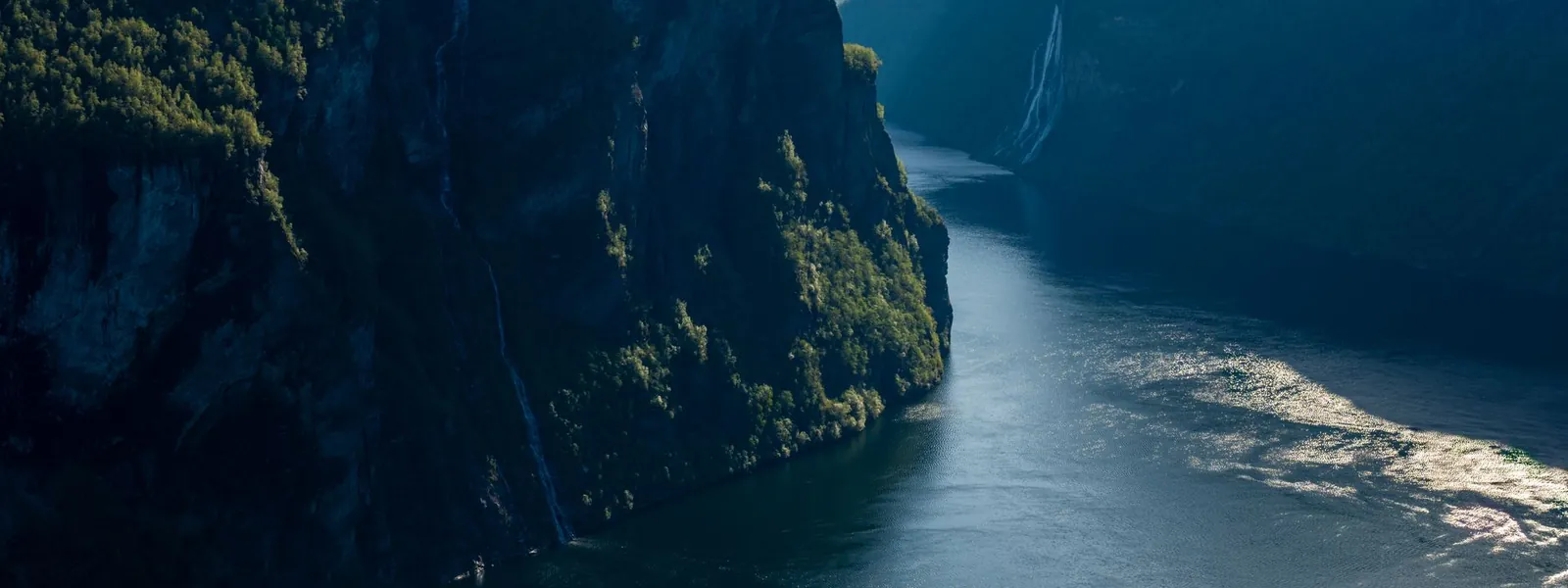 Fjord de Geiranger entouré de montagnes enneigées en Norvège