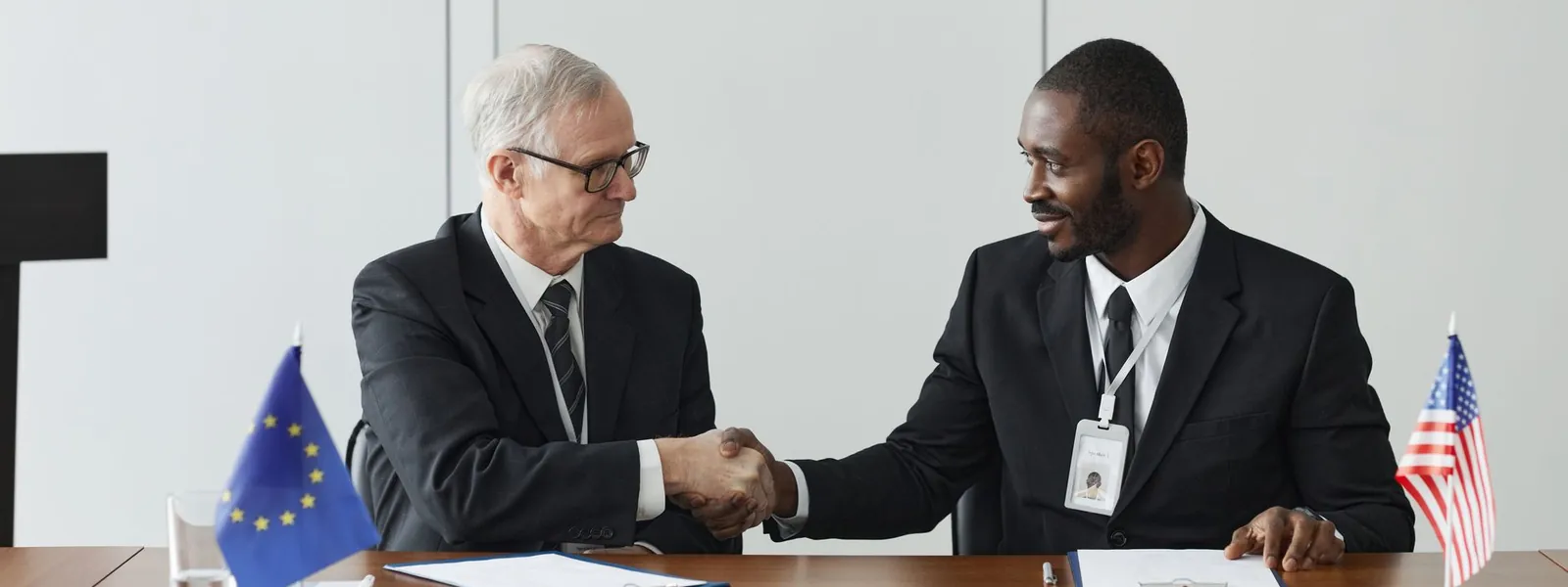 Poignée de main entre professionnels symbolisant un partenariat international pour stagiaires