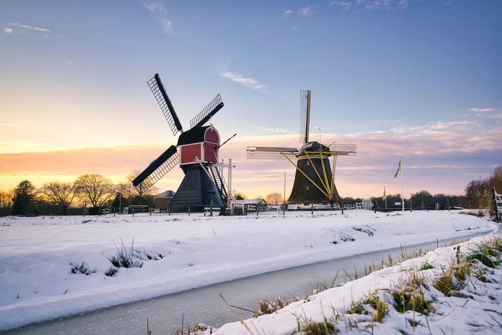 Moulins à vent néerlandais sous la neige au lever du soleil