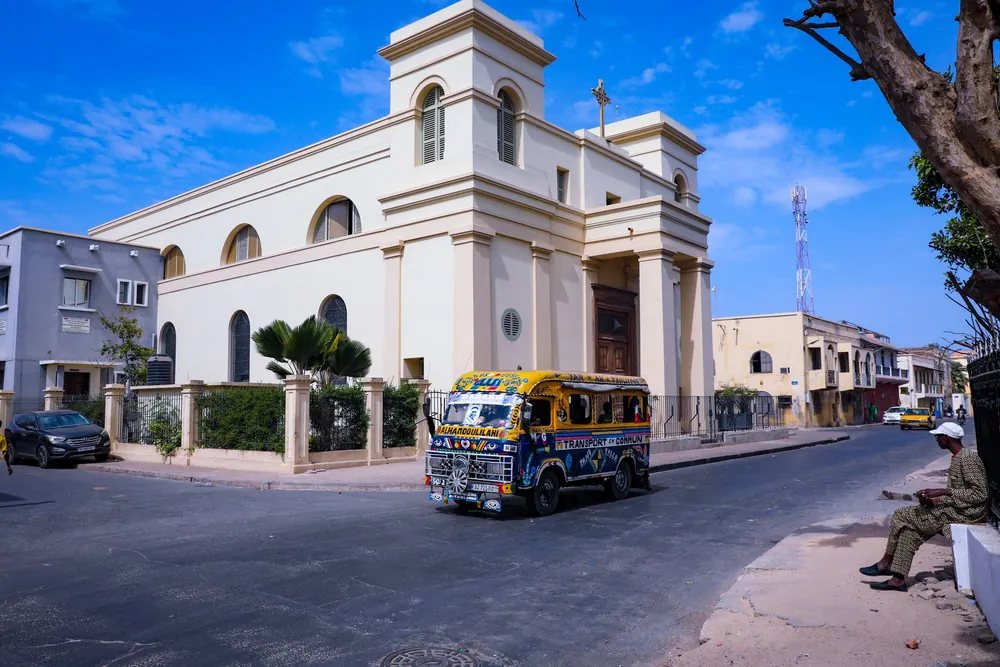 Minibus circulant dans les rues de Dakar près d'une église historique