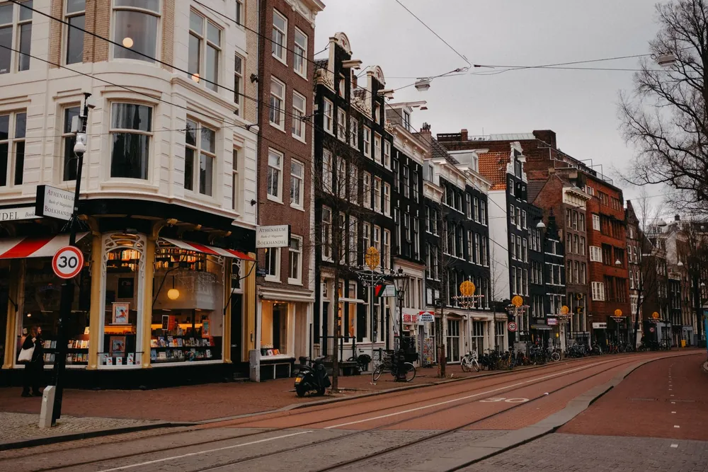 Rue pittoresque d'Amsterdam bordée de façades typiques et animée par la vie urbaine