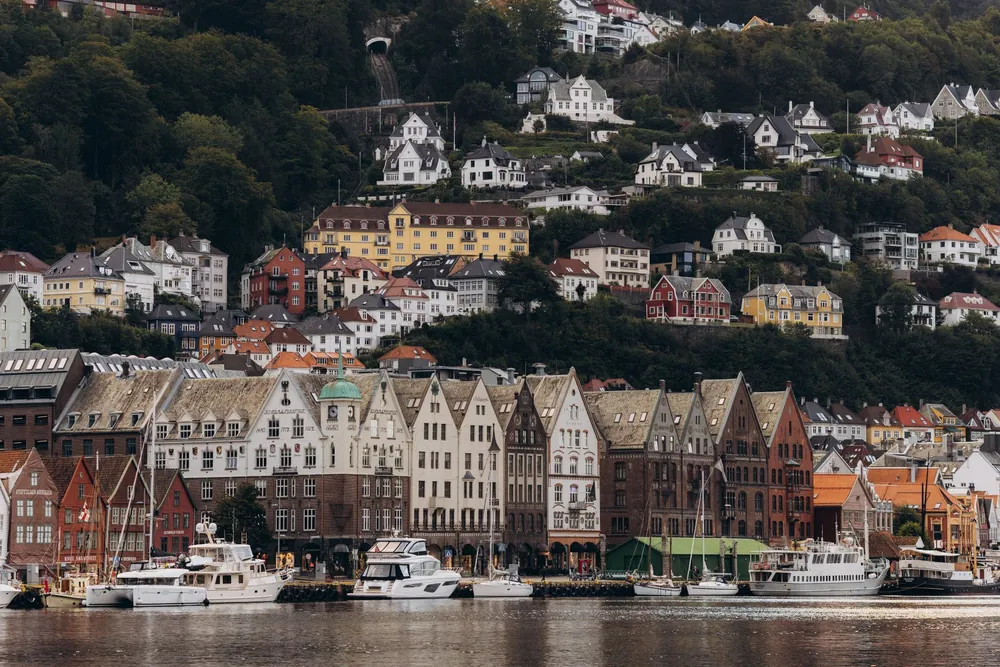 Quartier de Bryggen et maisons de colline sous un ciel nuageux à Bergen