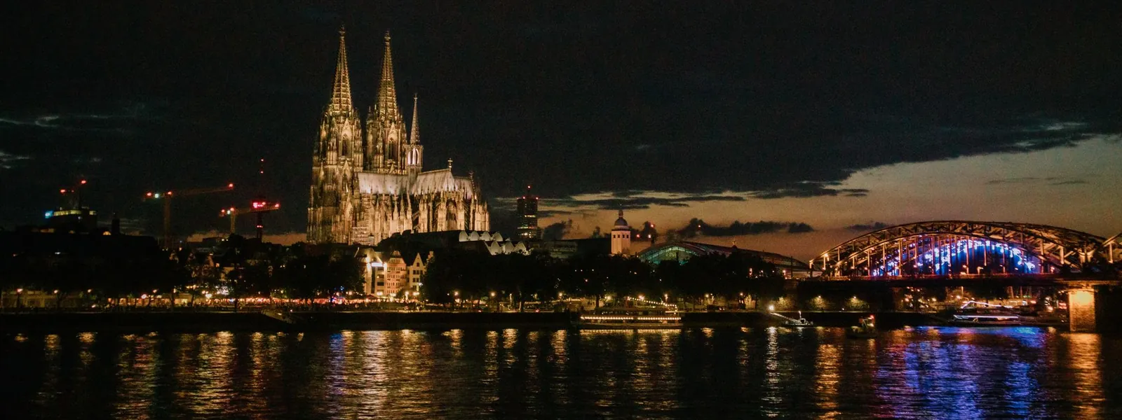 Cathédrale de Cologne et pont Hohenzollern illuminés la nuit au bord du Rhin