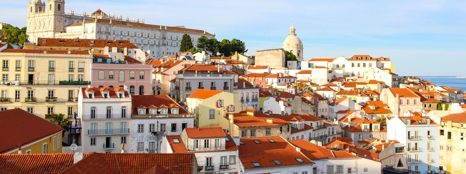 Quartier historique de l'Alfama à Lisbonne avec ses façades traditionnelles sous un ciel dégagé