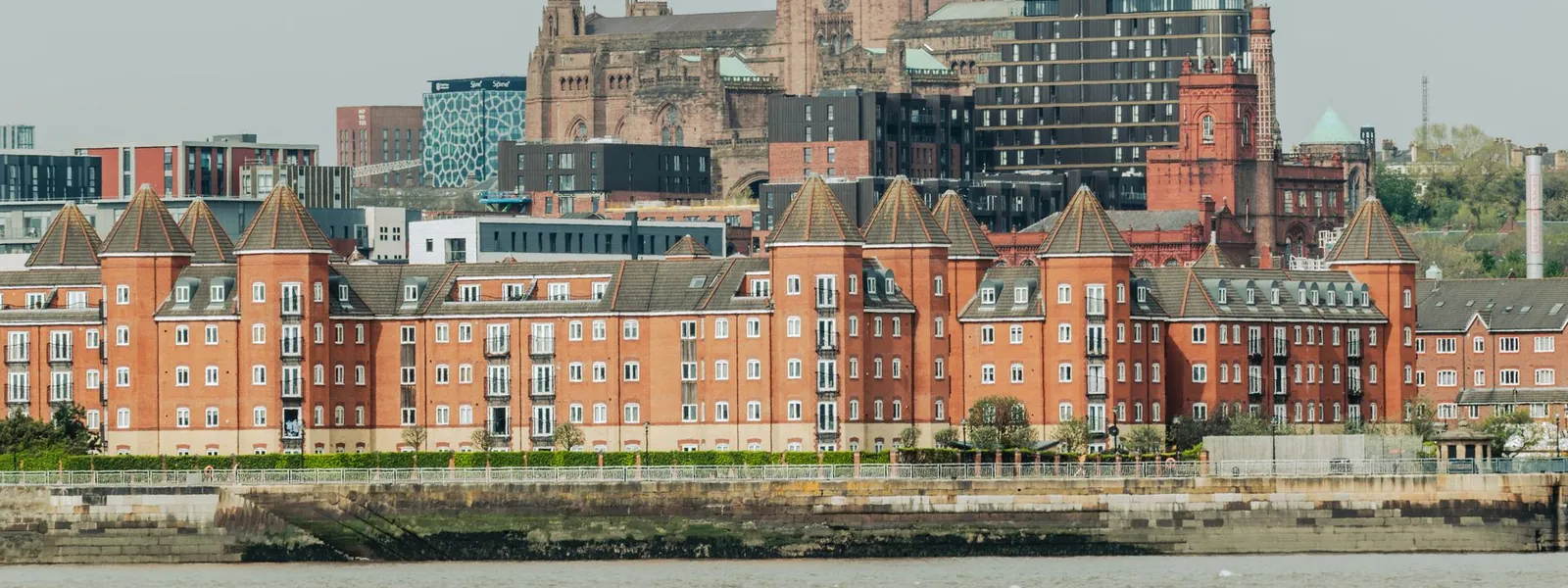 Cathédrale de Liverpool entourée de bâtiments en bord de rivière