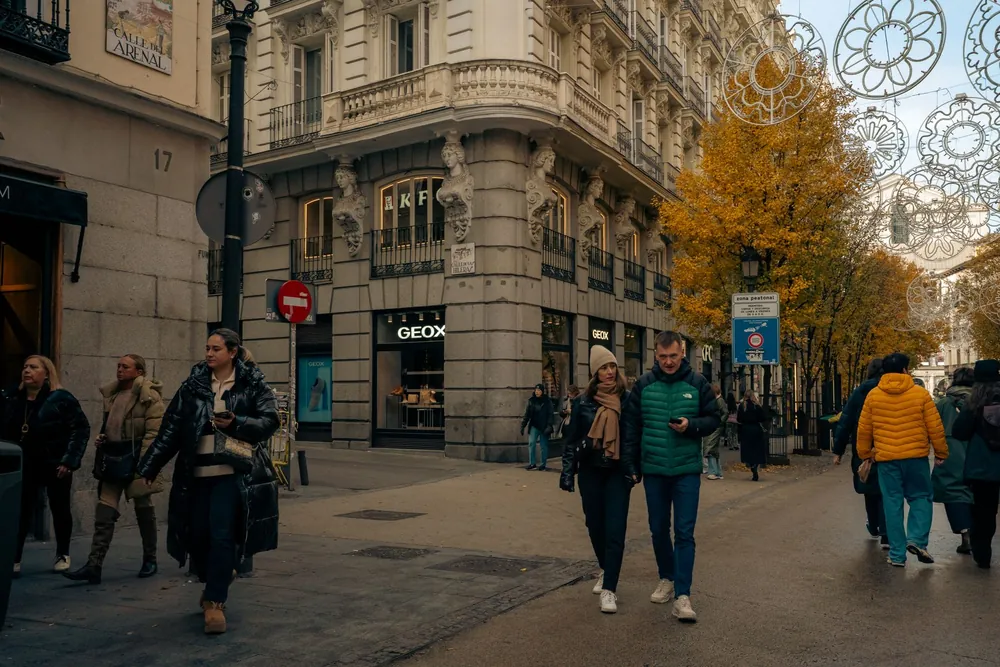 Rue animée de Madrid bordée d'arbres et de bâtiments historiques