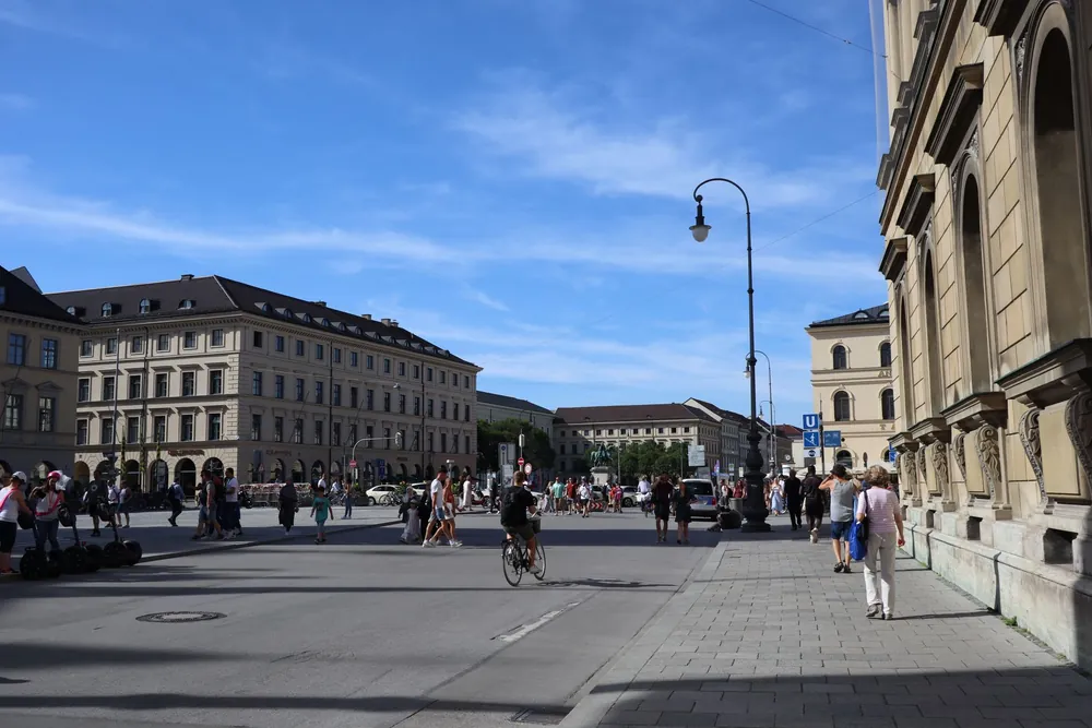 Odeonsplatz à Munich animée de piétons et cyclistes sous un ciel bleu