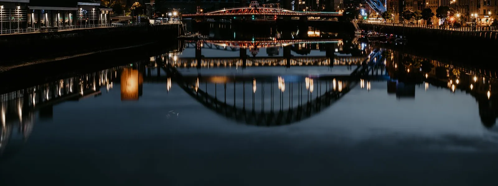 Pont de Tyne illuminé la nuit se reflétant dans la rivière à Newcastle