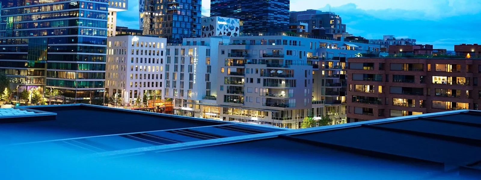 Immeubles modernes illuminés au crépuscule dans le centre-ville d'Oslo