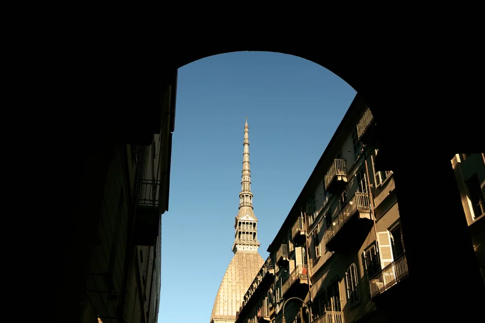 La Mole Antonelliana de Turin encadrée par une arche sous le ciel bleu