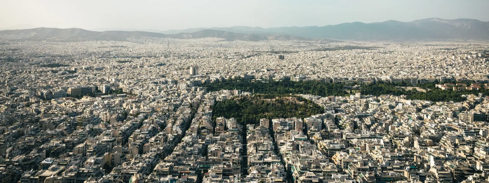 Une vue aérienne d'Athènes montre une ville dense entourée de montagnes