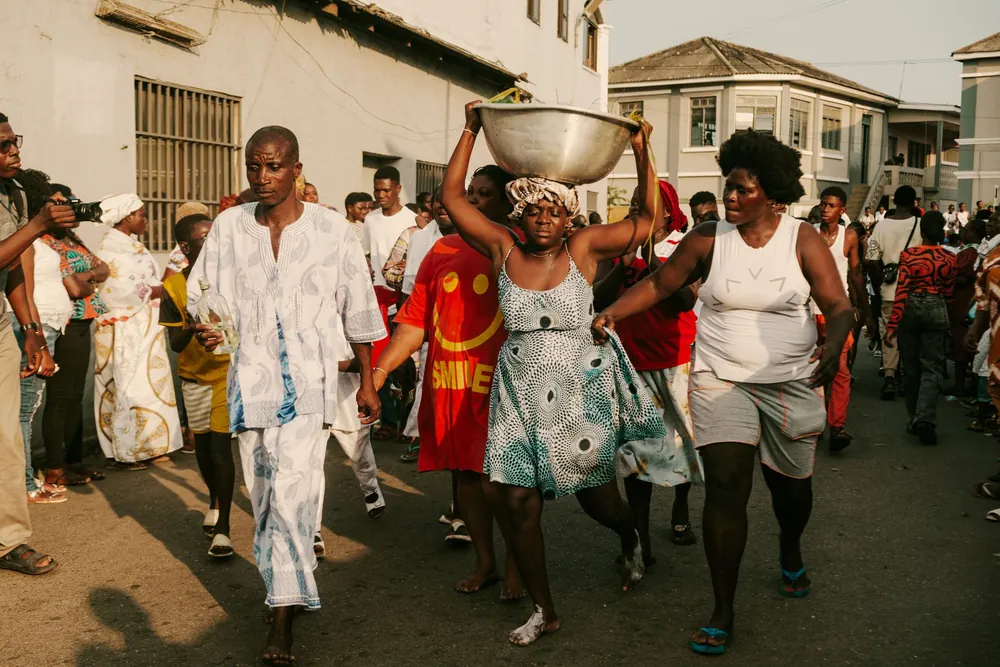Défilé animé dans une rue d'Accra reflétant la culture locale