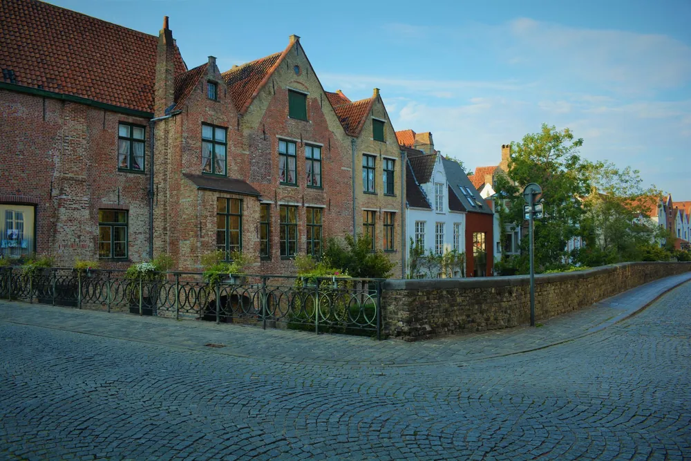Maisons médiévales alignées le long d'une rue pavée de Bruges