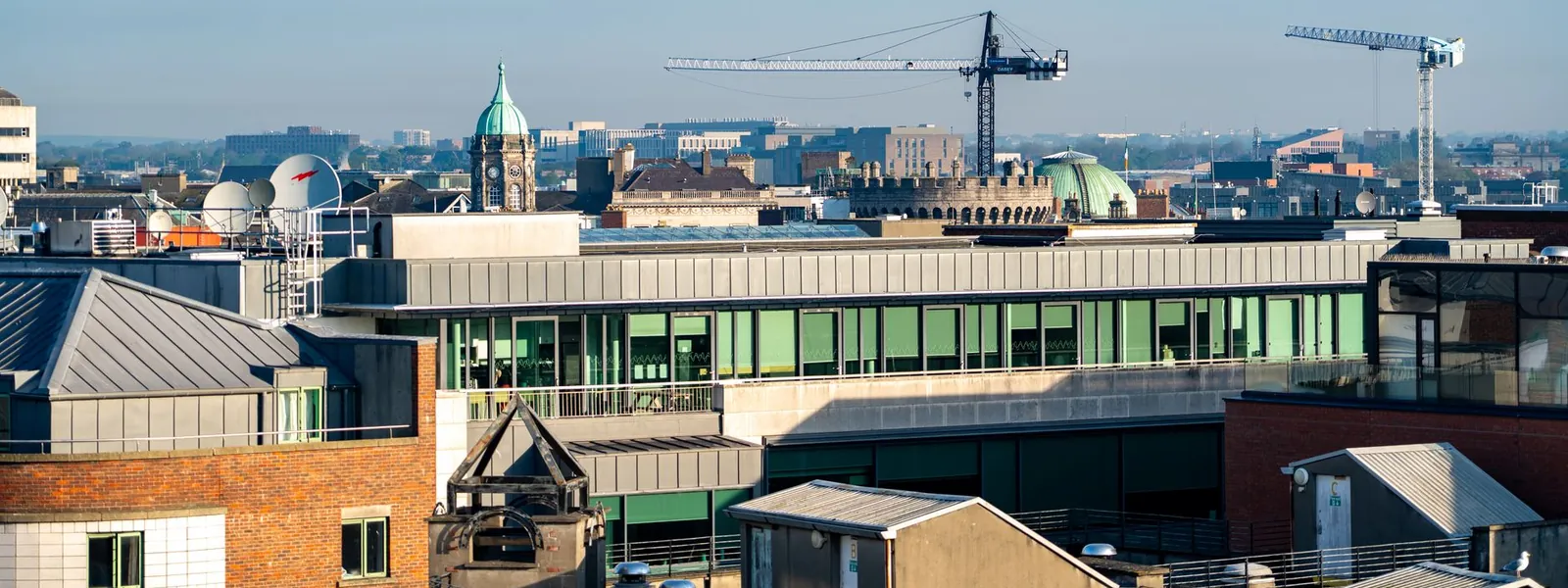 Grues de construction et architecture urbaine dans le ciel dégagé de Dublin