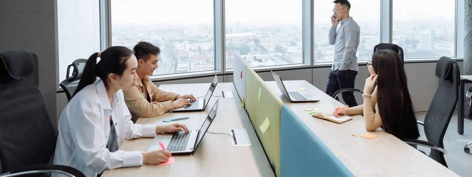 Équipe professionnelle travaillant dans un bureau moderne avec vue sur la ville