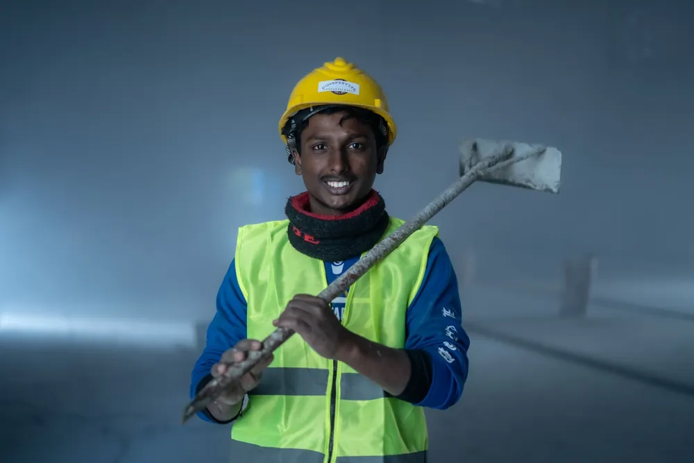 Jeune travailleur souriant en équipement de sécurité sur un chantier