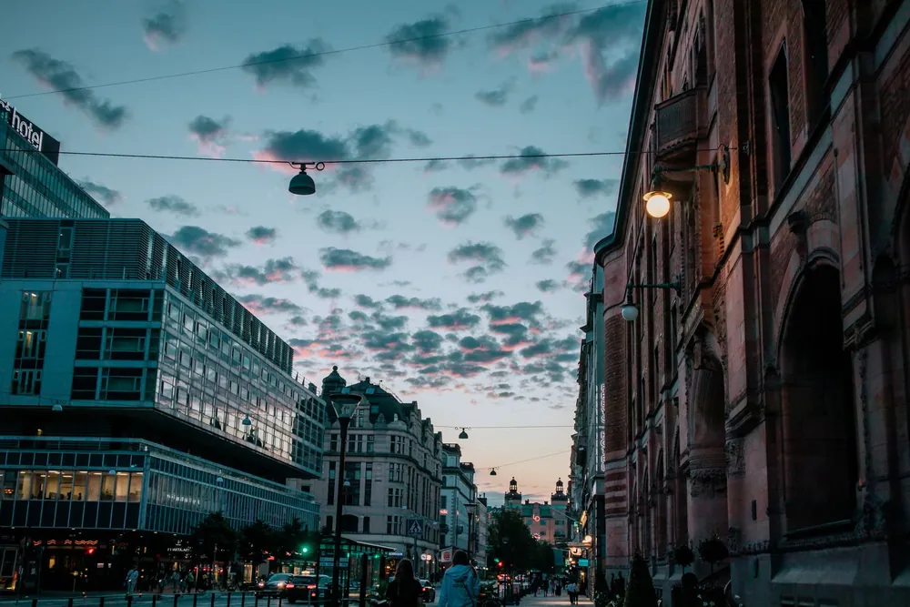 Rue suédoise au crépuscule mêlant architecture moderne et bâtiments anciens