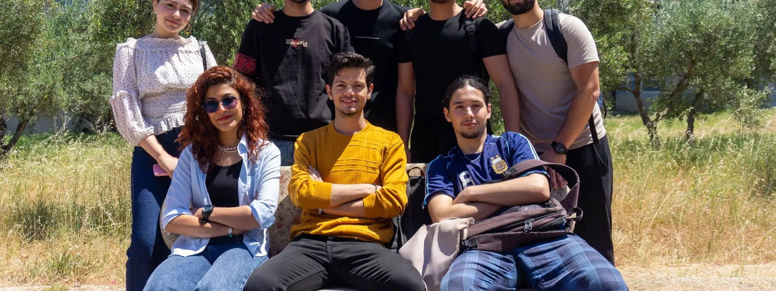 Groupe de jeunes stagiaires posant ensemble en extérieur sur un campus