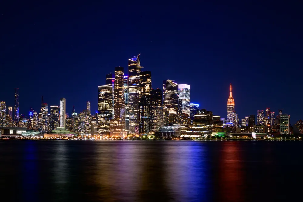 Skyline de New York illuminée se reflétant sur l'eau la nuit